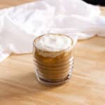 Latte topped with cheese cold foam in a glass mug.