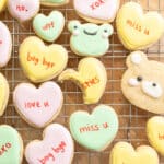 Cute conversation heart, frog, and bear cookies on a wire rack.