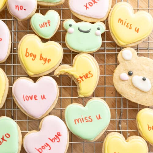 Cute conversation heart, frog, and bear cookies on a wire rack.