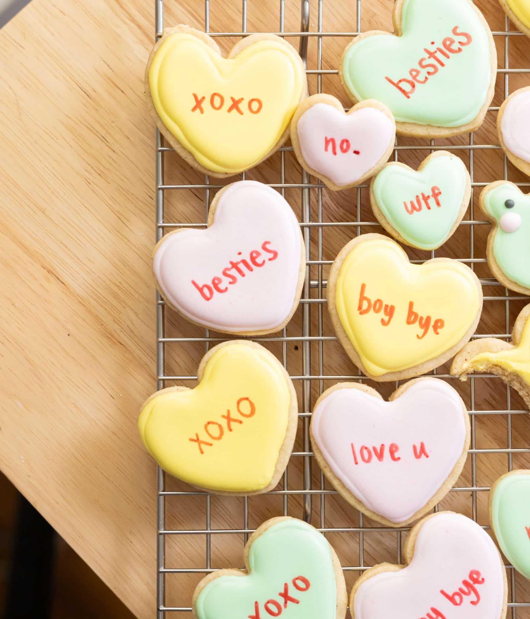 Conversation heart cookies on a wire rack.