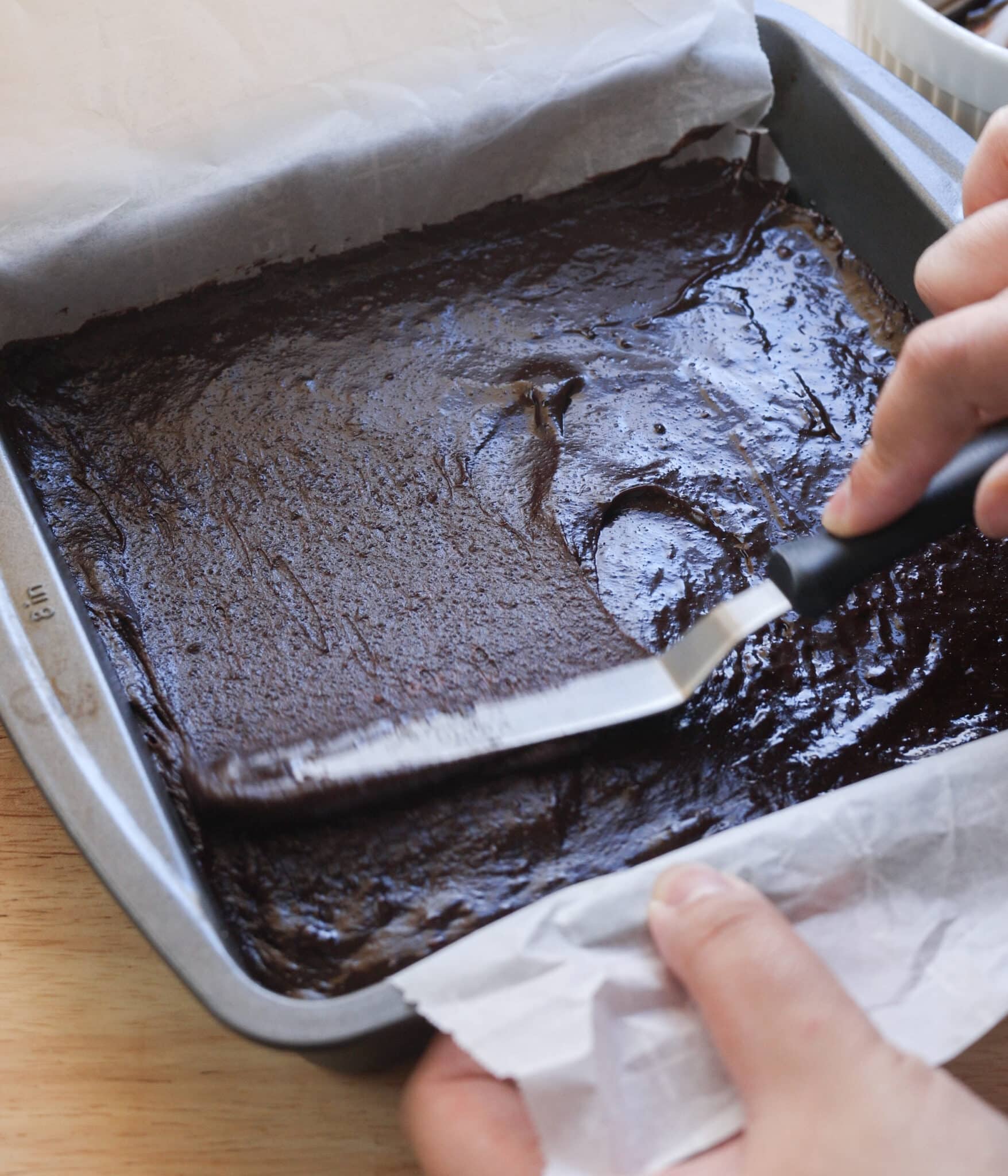 Spreading brownie batter into 8x8 pan.