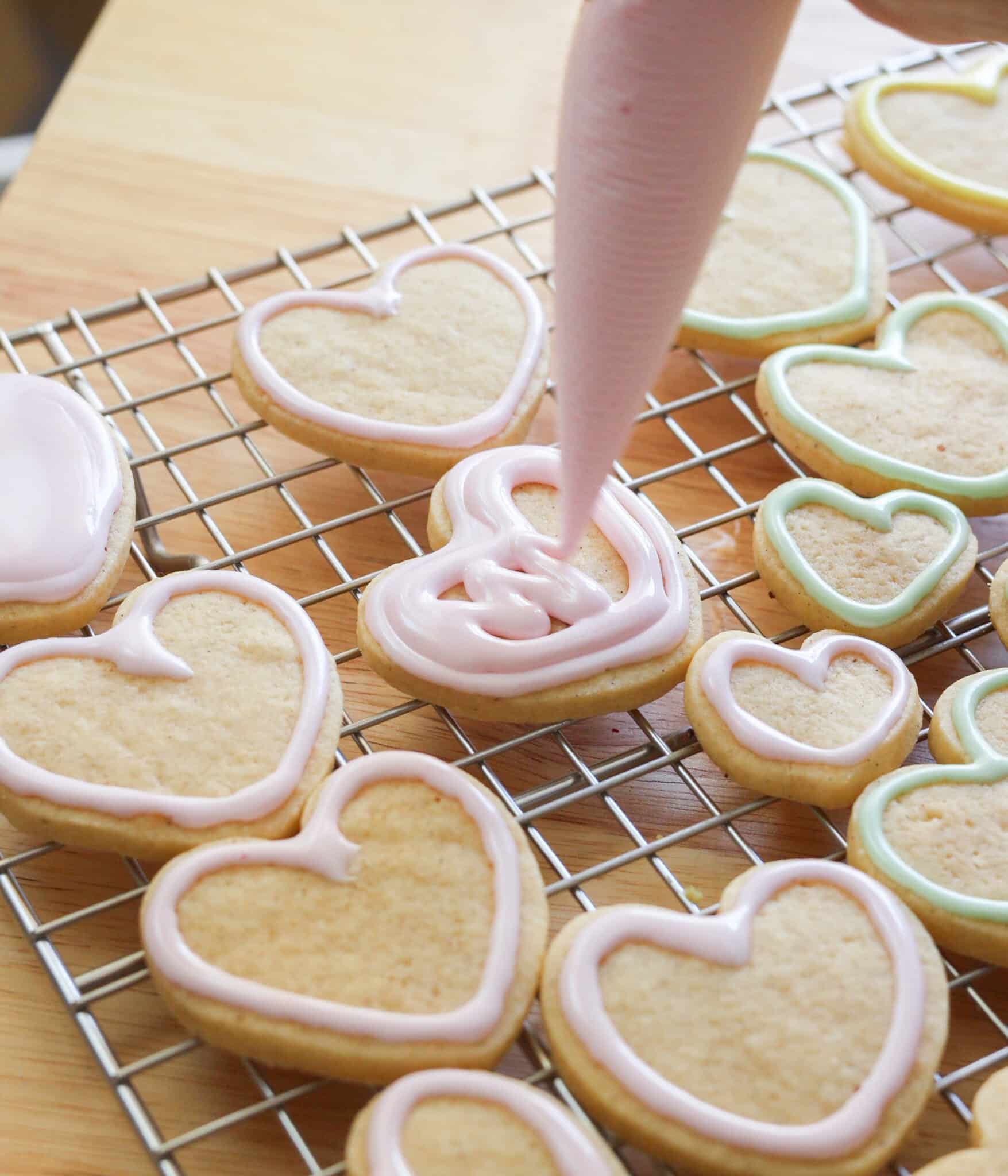Using royal icing to decorate rolled sugar cookies.