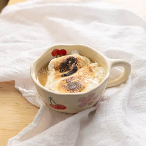 Earl Grey hot chocolate in a mug topped with torched marshmallow fluff.