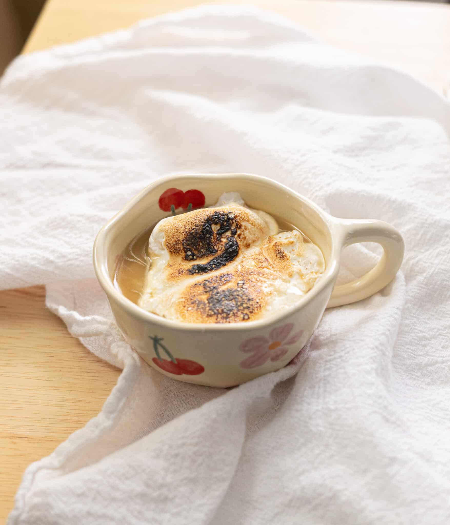Earl Grey hot chocolate in a mug topped with torched marshmallow fluff.