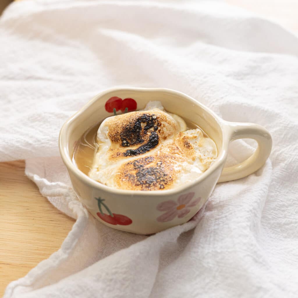 Earl Grey hot chocolate in a mug topped with torched marshmallow fluff.