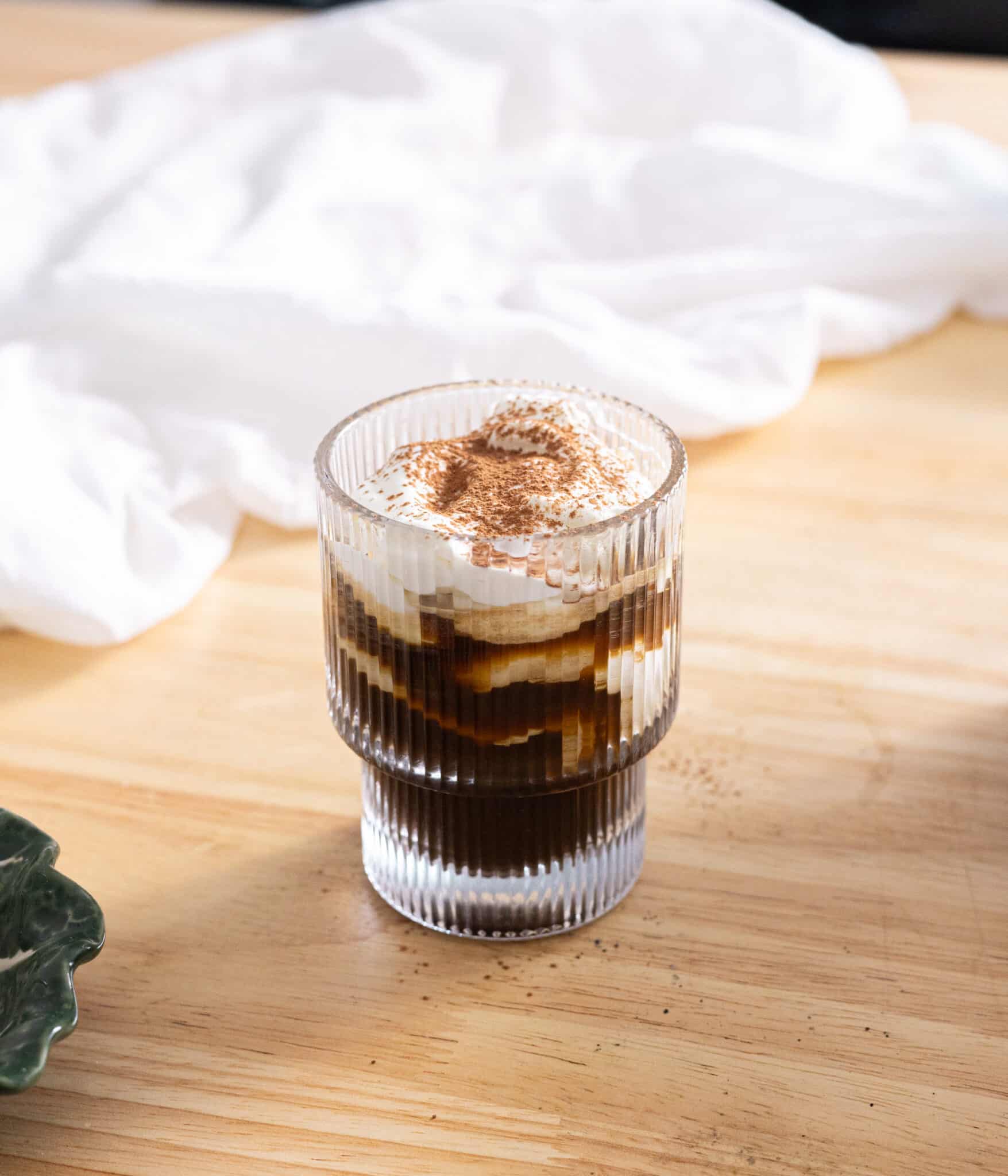 Einspanner topped with cocoa powder in a glass cup.
