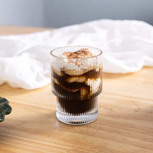 Einspanner topped with cocoa powder in a glass cup.