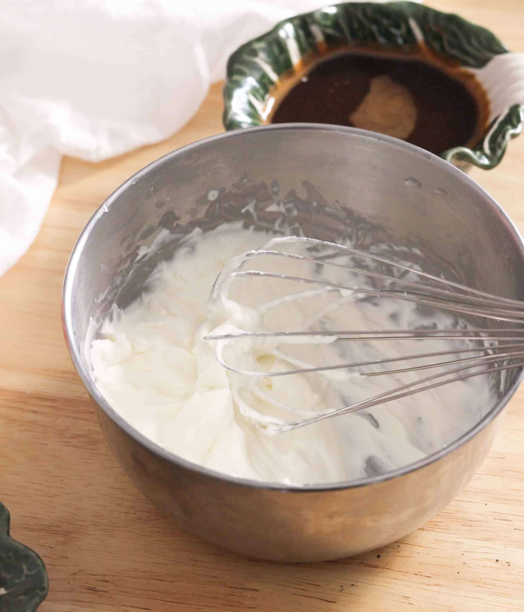 Homemade whipped cream in a stainless steel bowl.