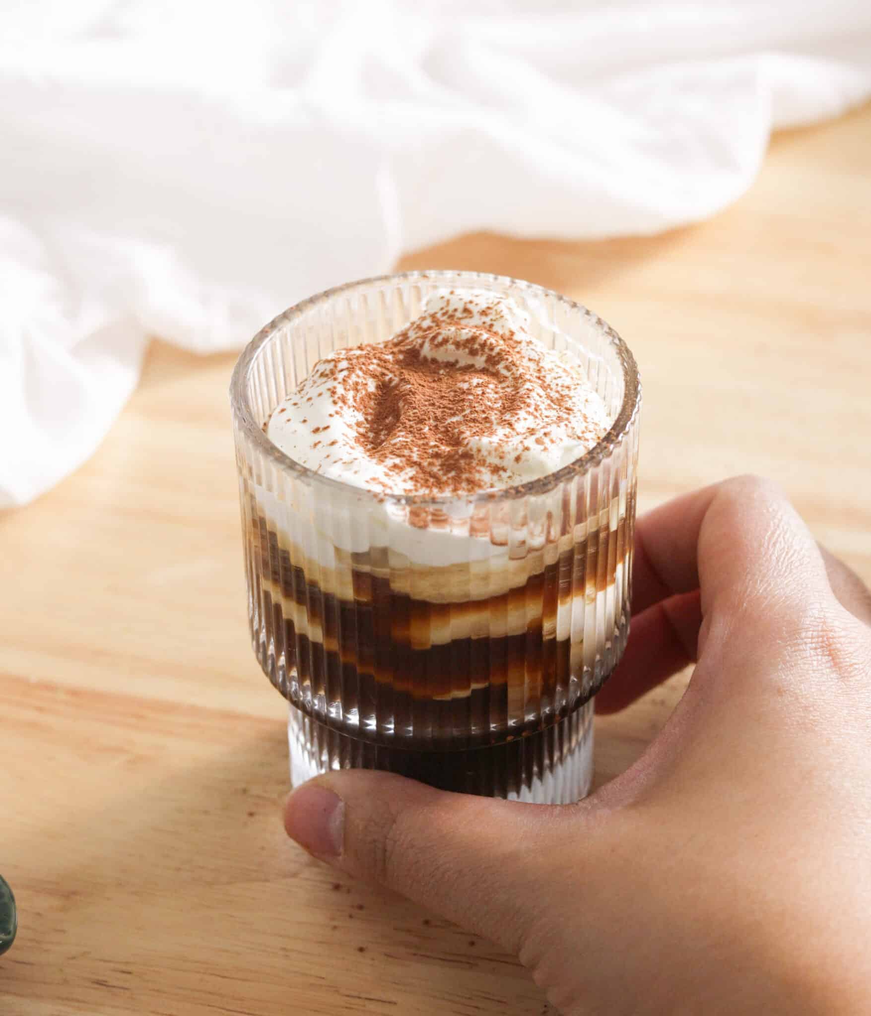 Holding glass cup with einspanner in hand.