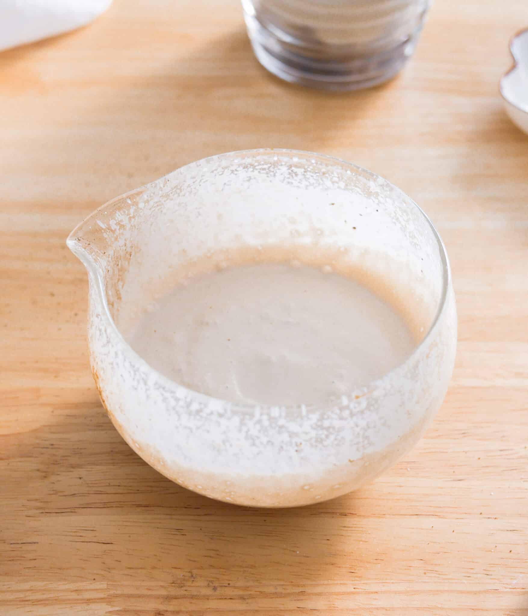 Frothed hojicha cold foam in a glass bowl.