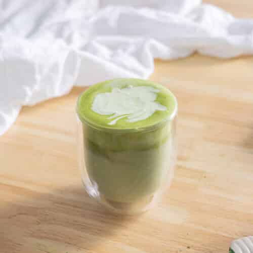 Matcha latte topped with matcha cold foam in a glass cup.