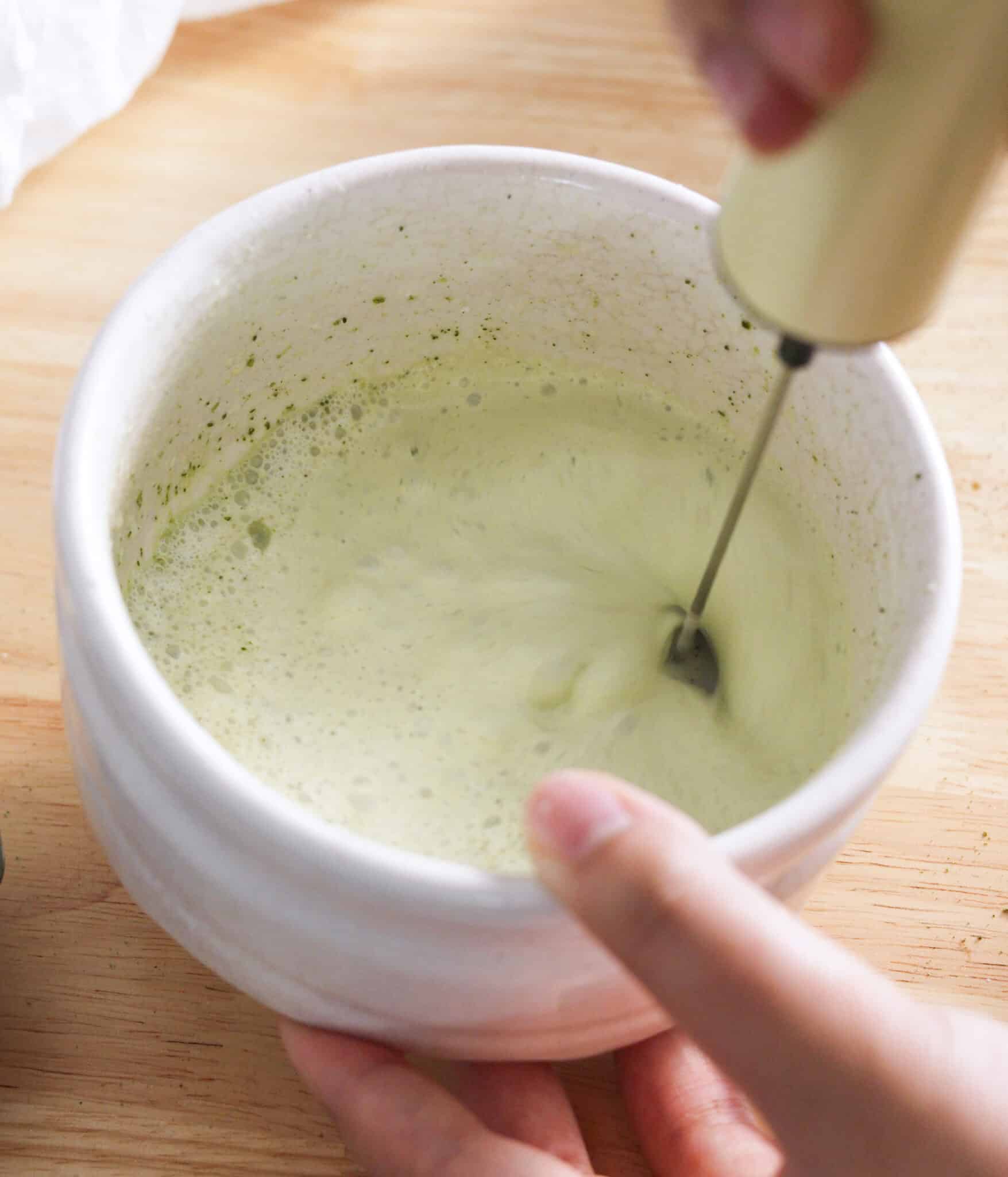 Frothing matcha cold foam in a matcha bowl.