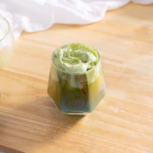 Matcha einspanner in a glass cup.