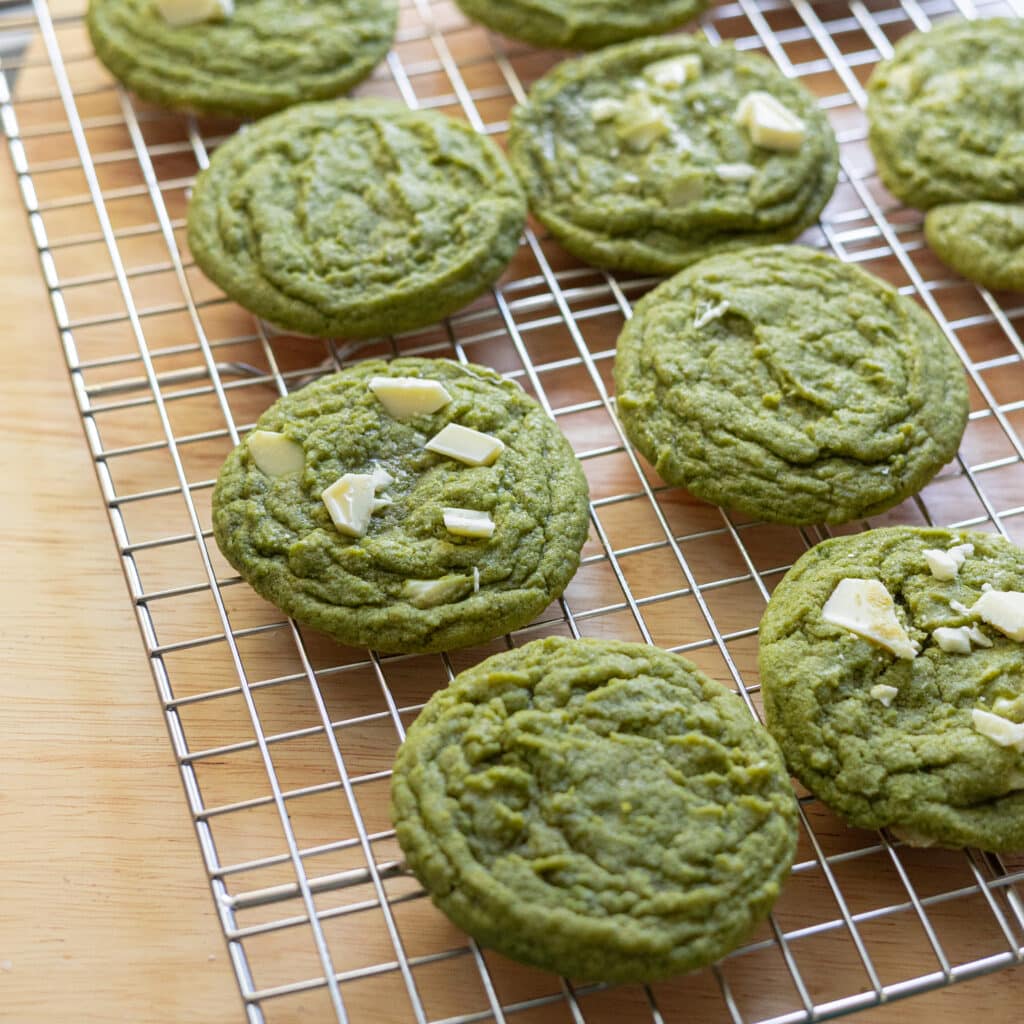 Matcha white chocolate cookies on a wire rack.