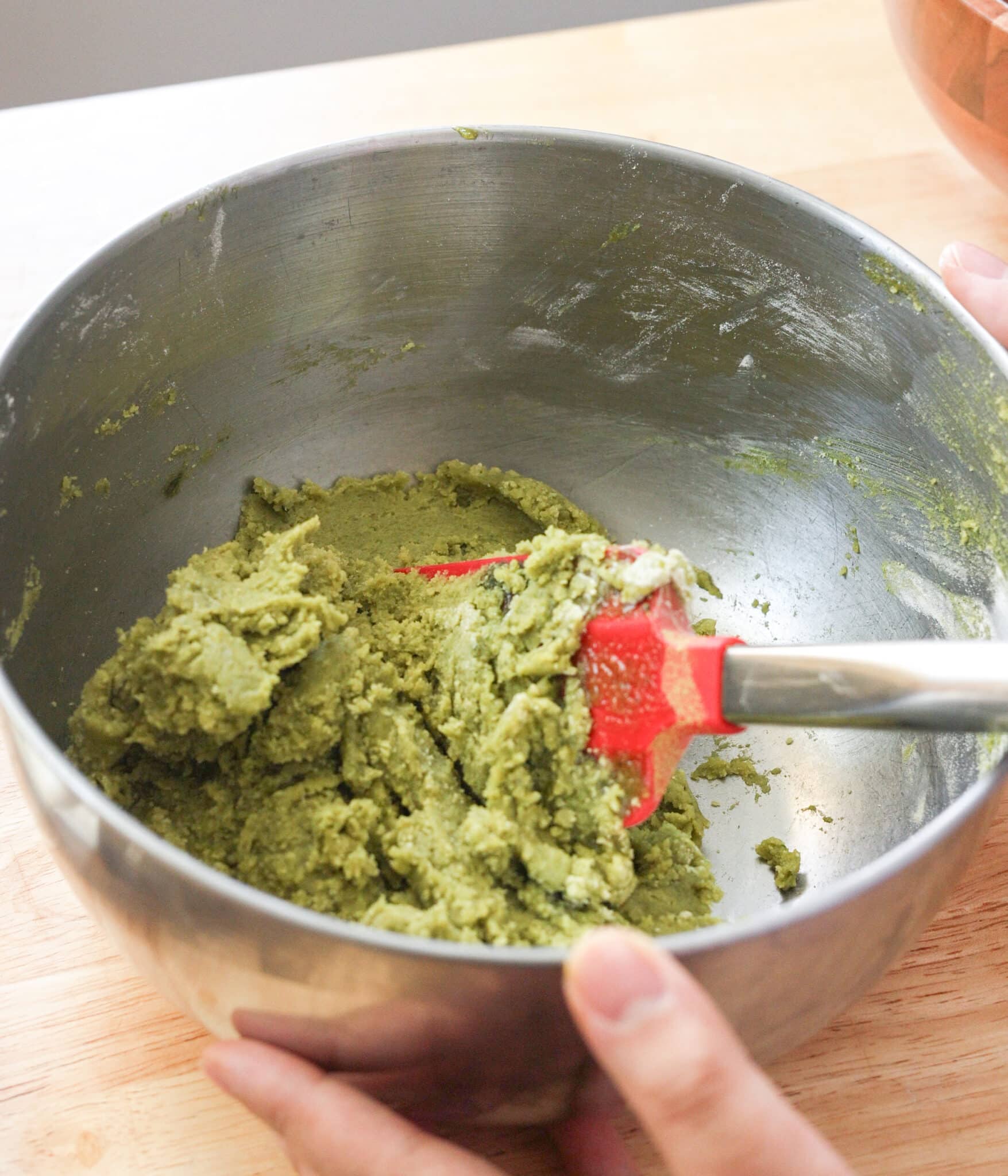 Matcha white chocolate chip cookie dough in a bowl.