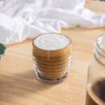 Latte topped with vanilla cold foam in a glass mug.