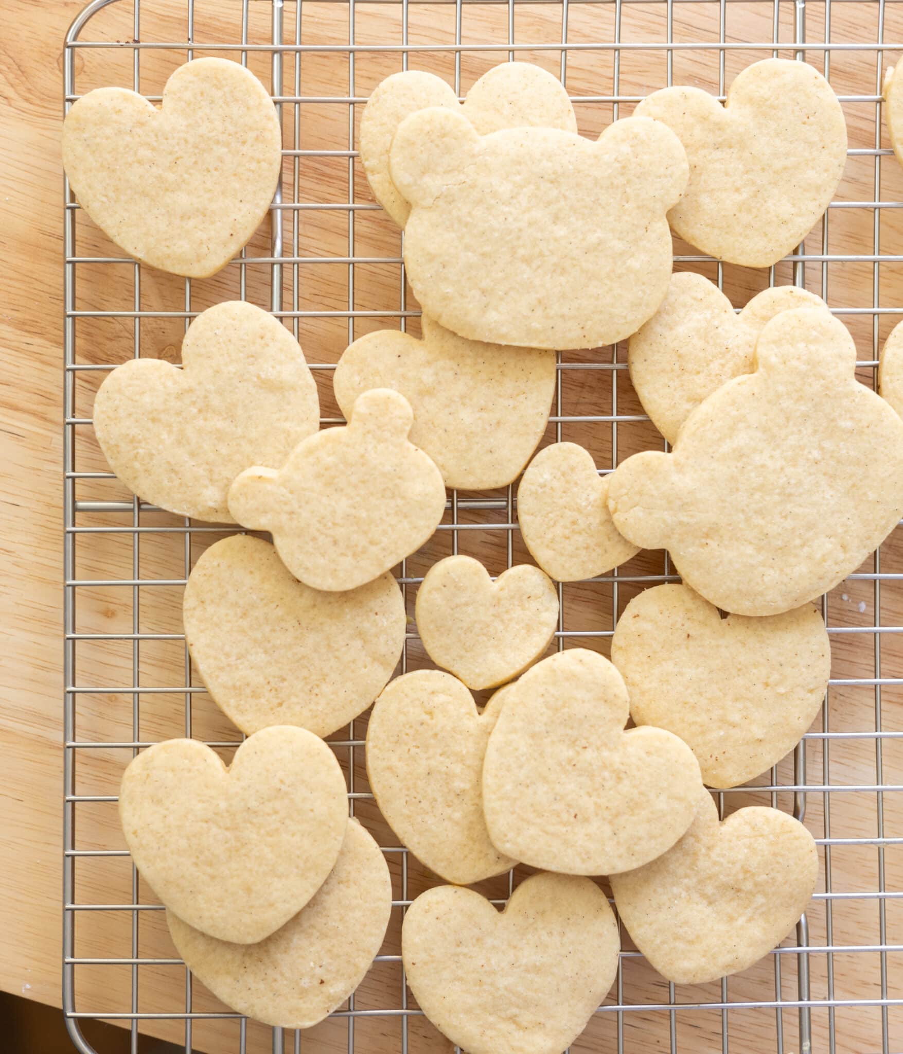 Cut out vanilla sugar cookies on a wire rack, in heart and bear shapes.