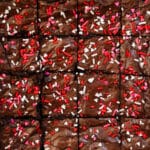 Valentine's Day brownies in a pan, topped with heart sprinkles.