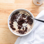 Bowl of chocolate champorado with evaporated milk poured on top.