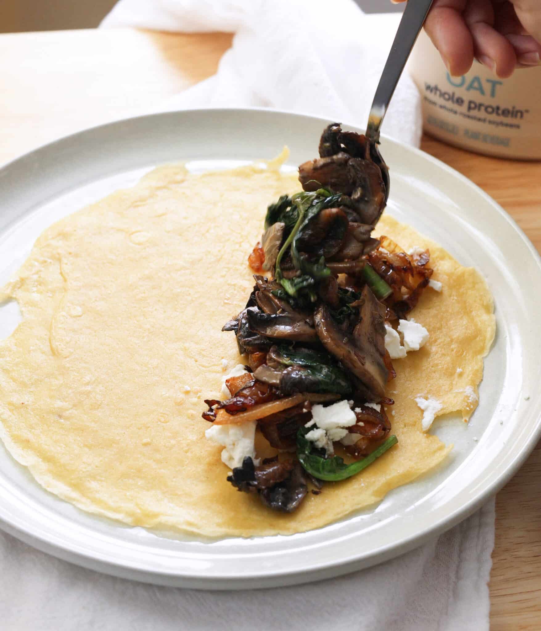 Adding savory filling to cooked crepe.