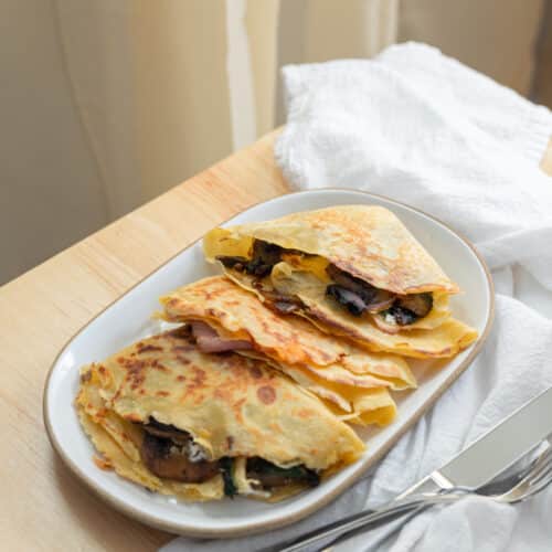 Two types of savory crepes on a plate.