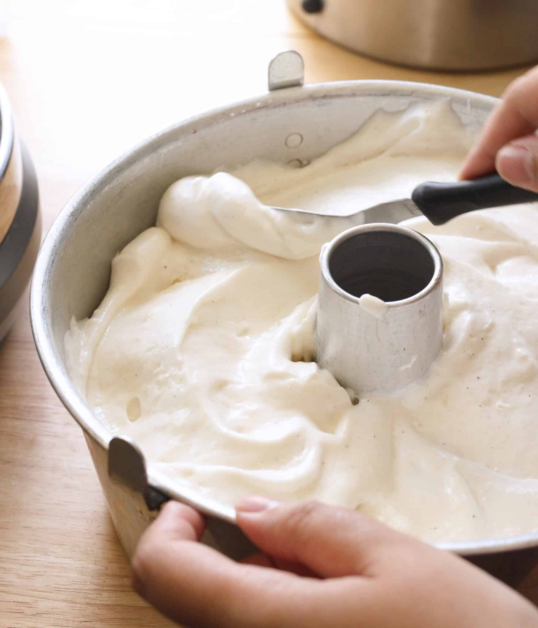 Spreading angel food cake batter into cake pan.