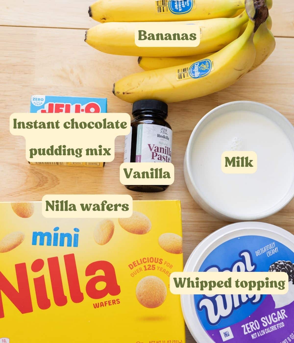 Homemade chocolate banana pudding labeled ingredients on a wooden table.