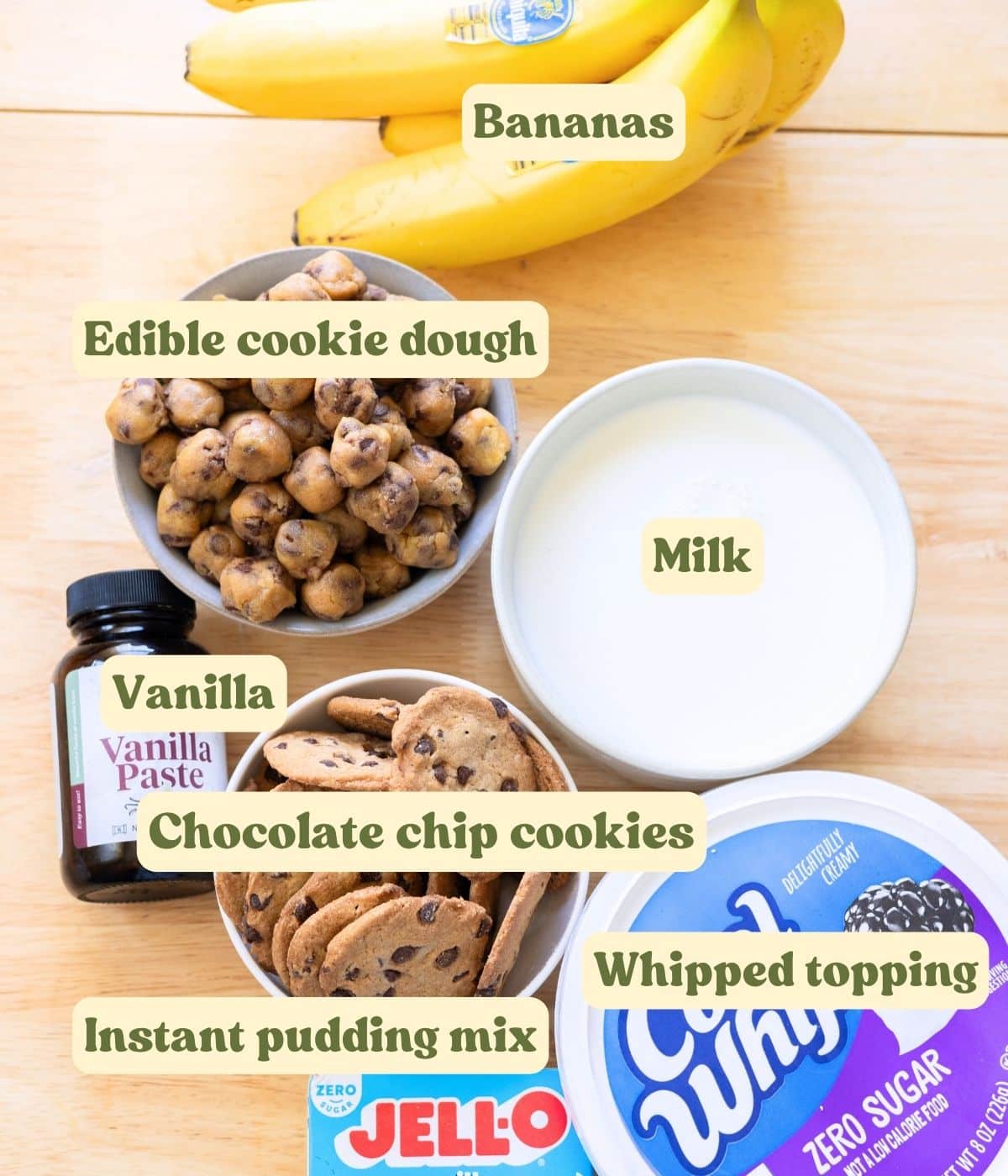 Homemade cookie dough banana pudding labeled ingredients on a wooden table.