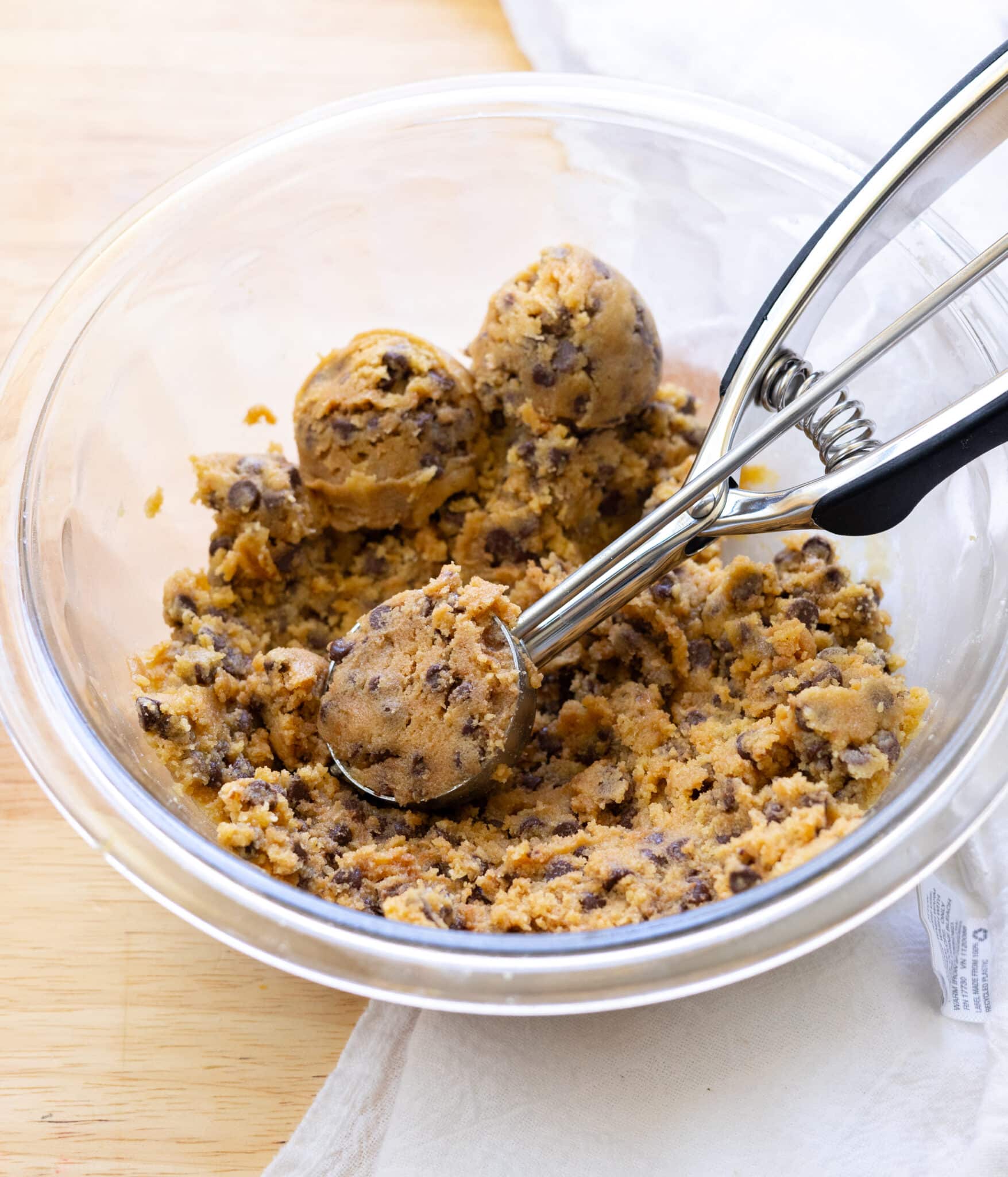 Scoopable edible cookie dough in a glass mixing bowl.