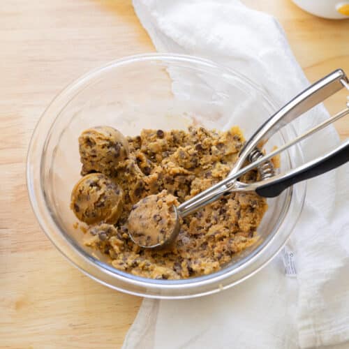 Scoopable edible cookie dough in a glass mixing bowl.