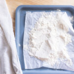 Heat treated flour on a lined baking sheet.