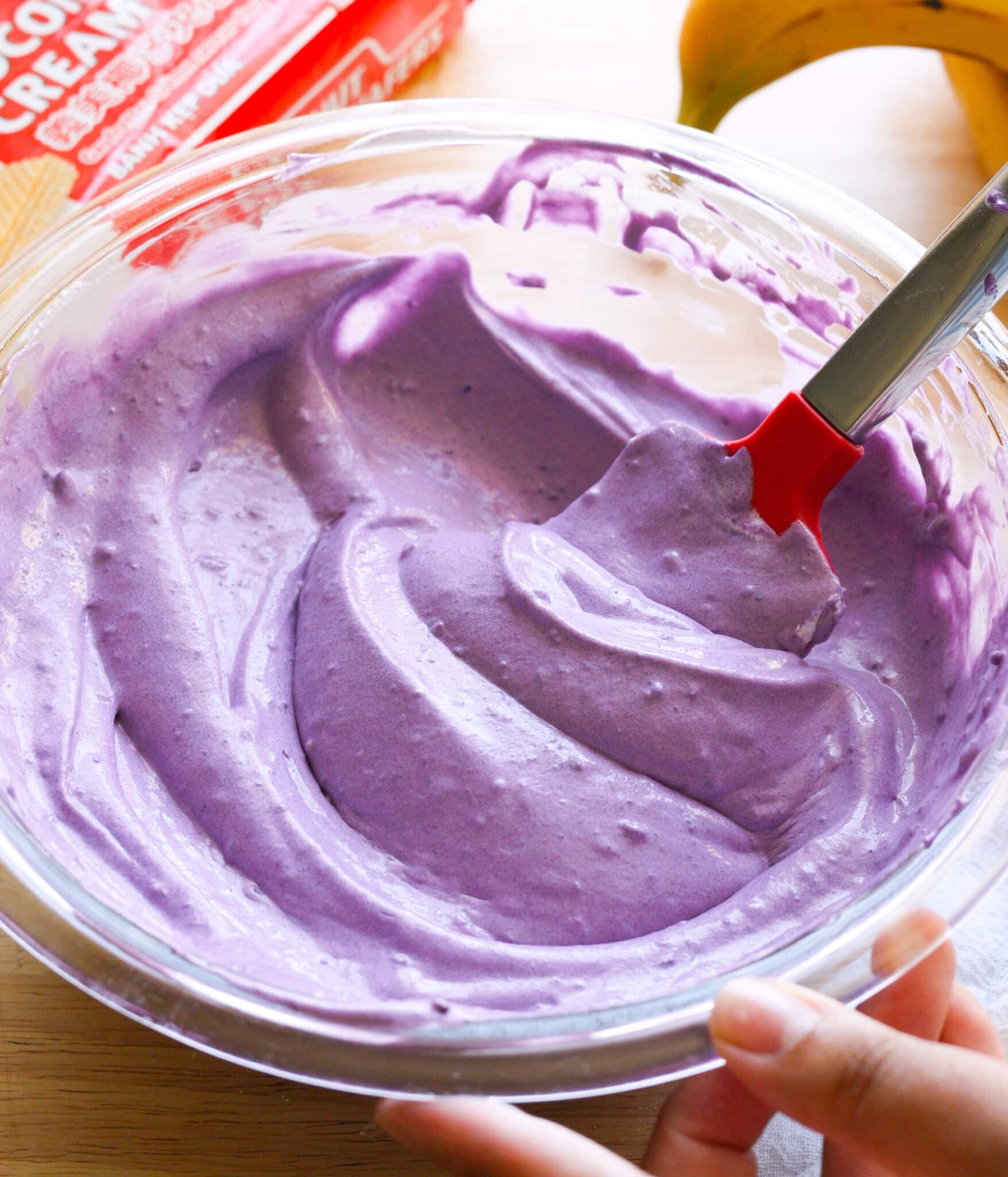 Light and creamy ube banana pudding mixture in a glass bowl.