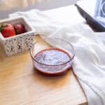 Strawberry syrup in a glass container.