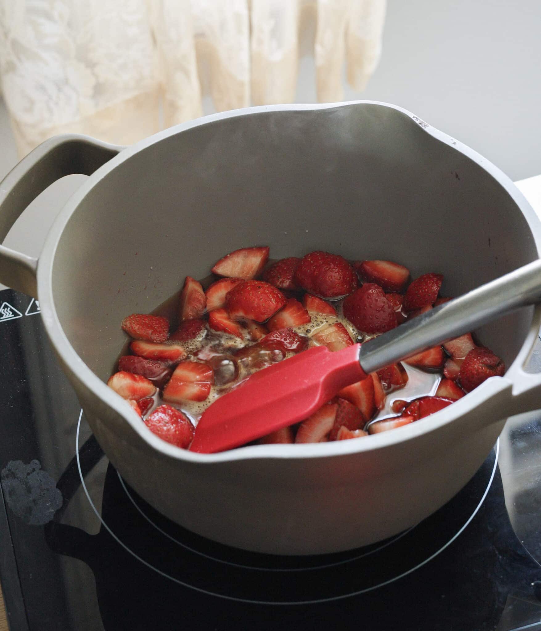 Cooking strawberries, water, and sugar in a medium pot.