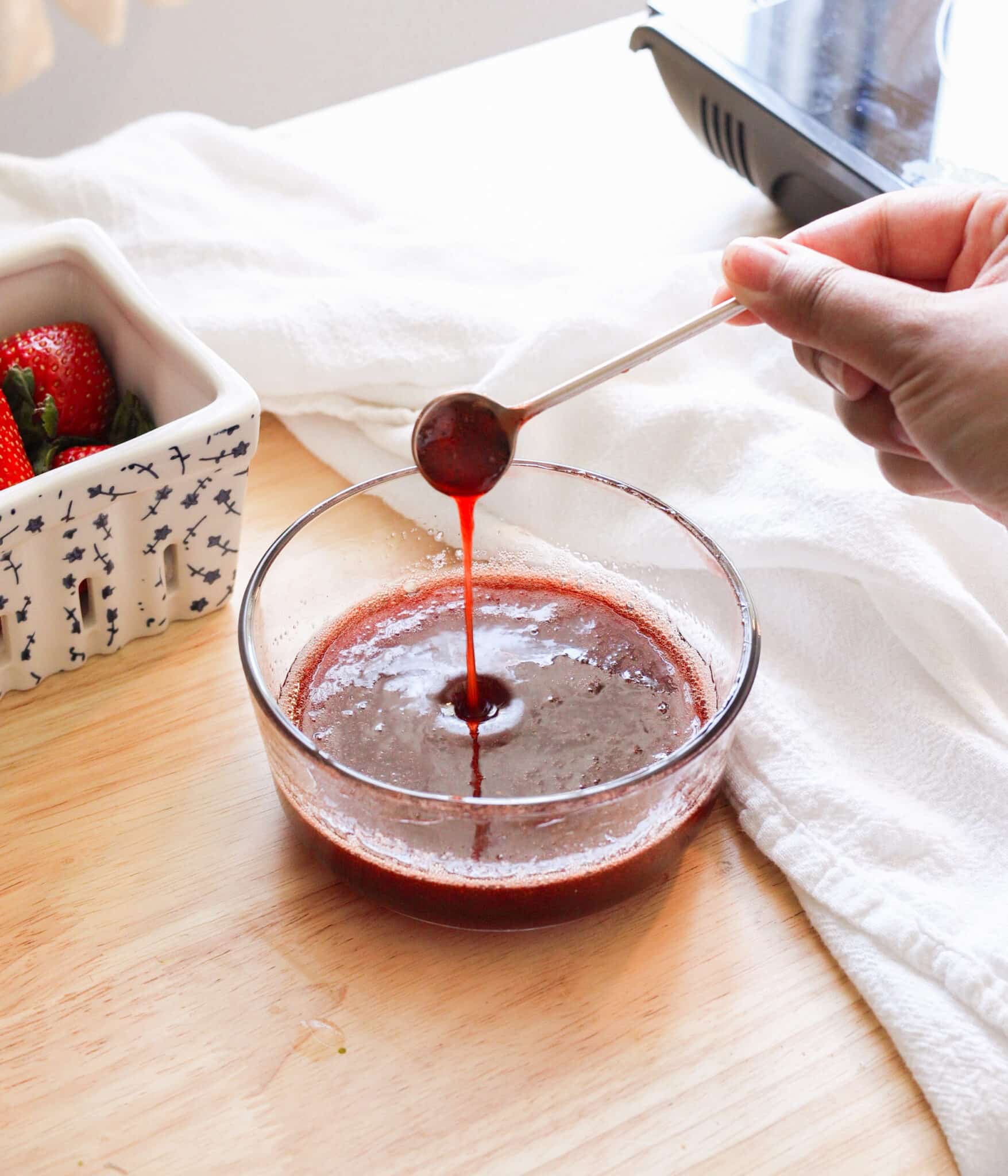 Strawberry syrup in a glass container.