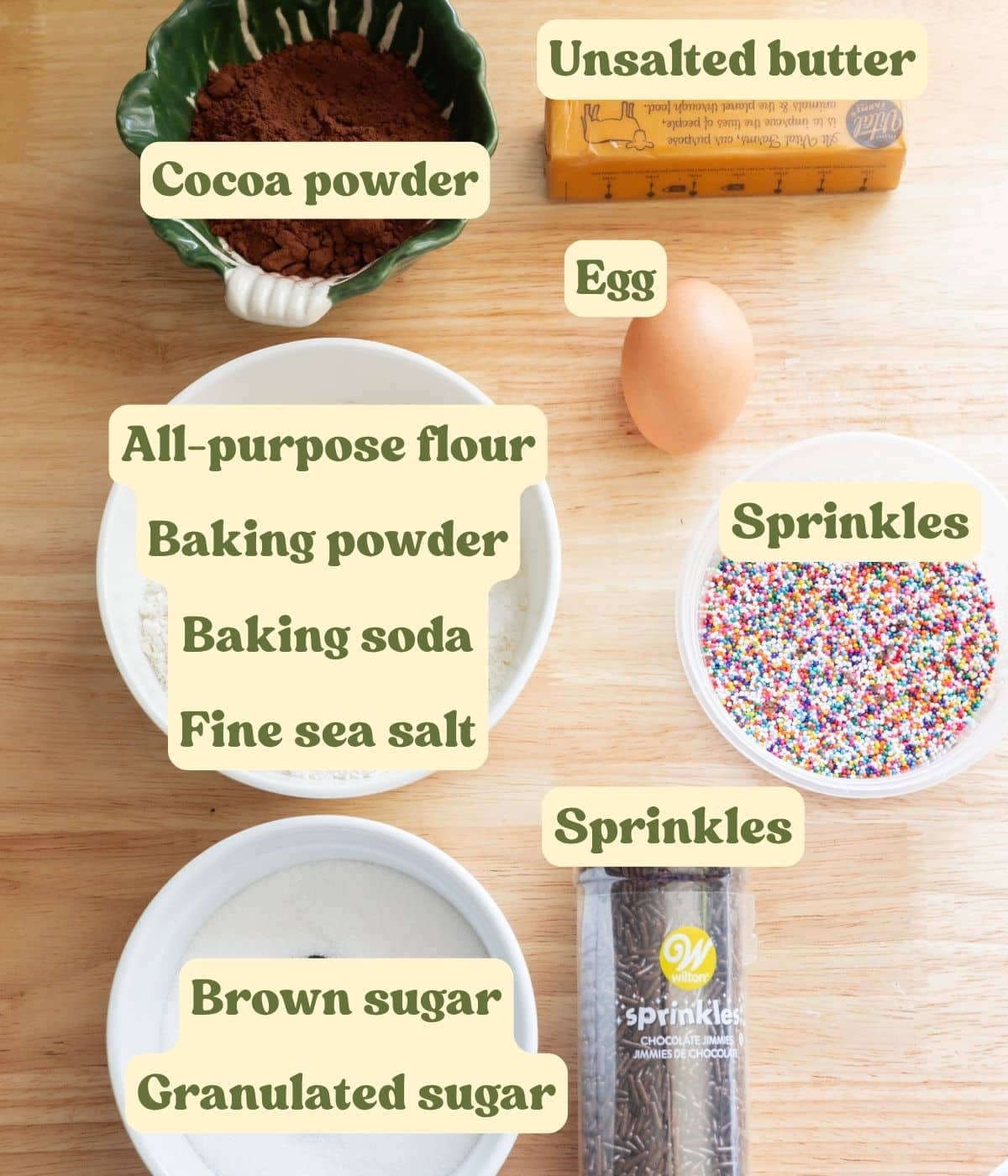 Chocolate sprinkle cookie ingredients laid out on a table with labels.
