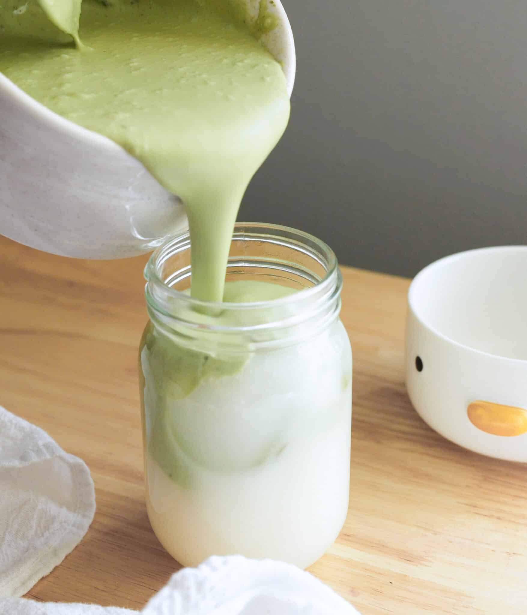 Pouring coconut mixture on top of coconut juice.