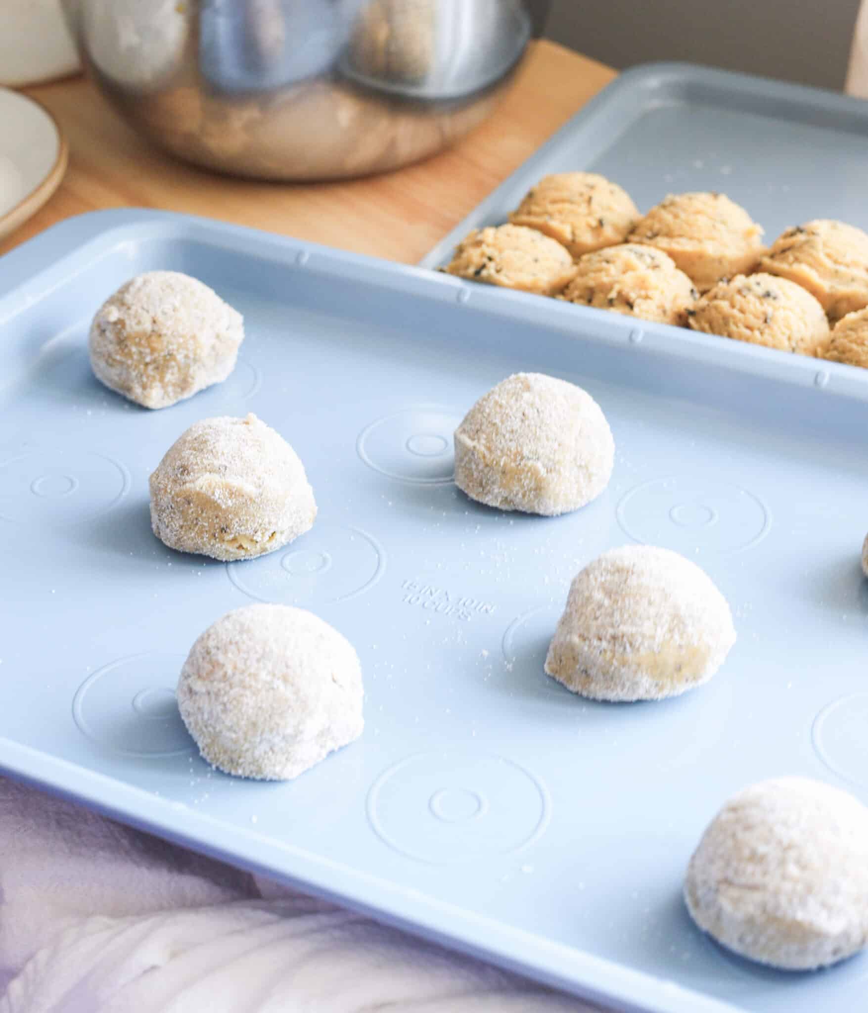 Jasmine sugar cookie dough balls rolled in sugar, ready to be baked.