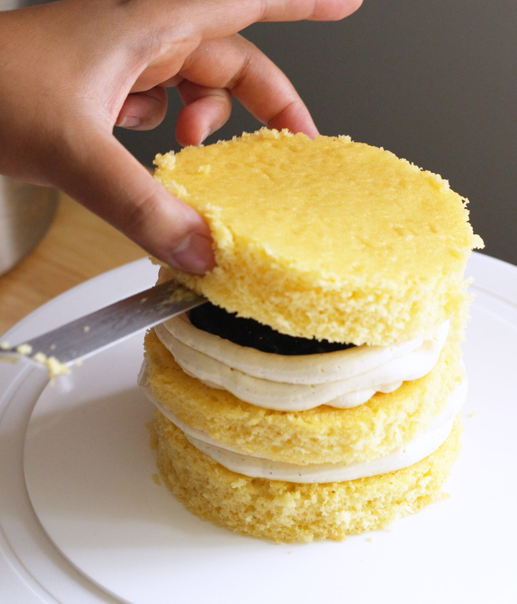 Layering cake on top of Swiss meringue buttercream and blueberry jam.