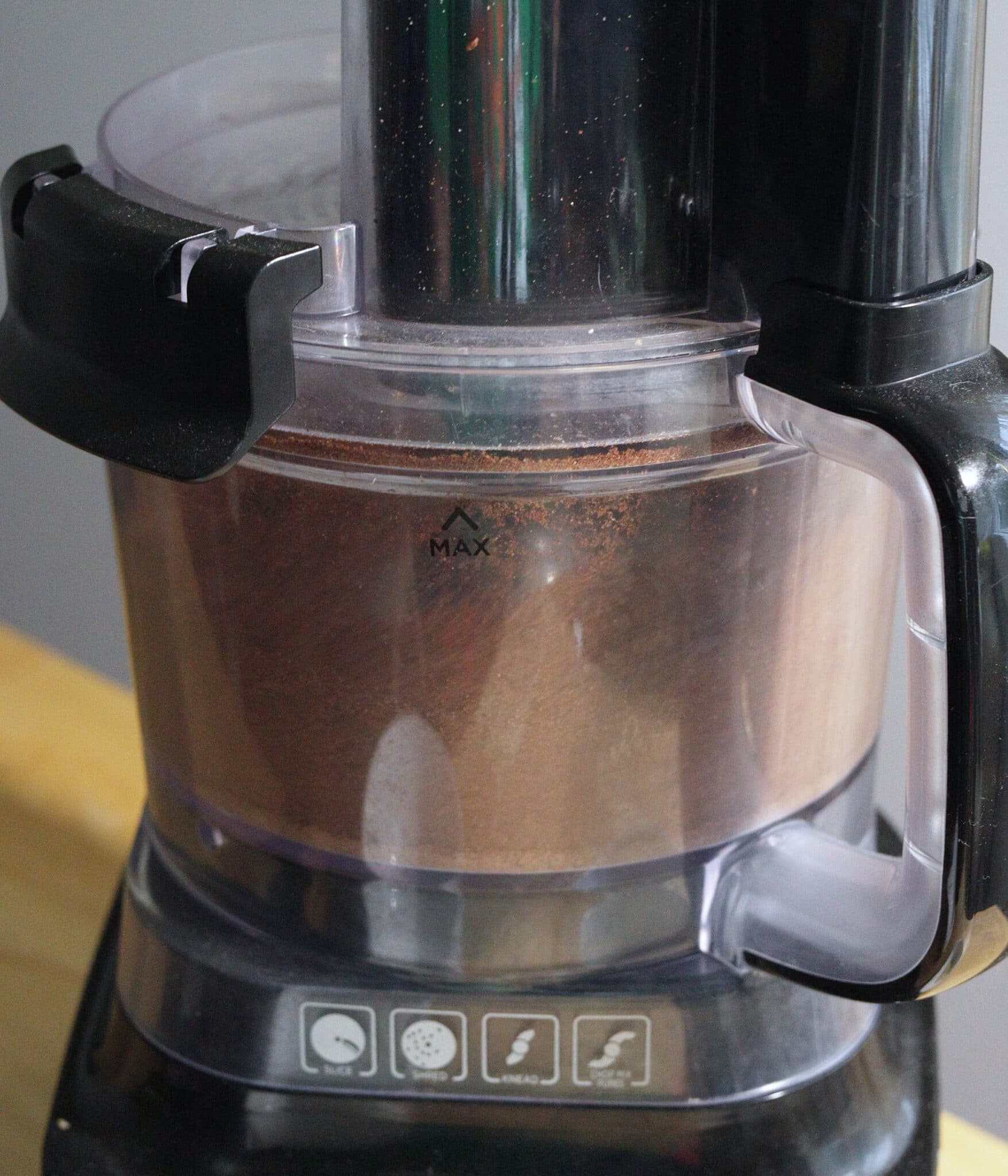 Grinding roasted cacao beans in a food processor.