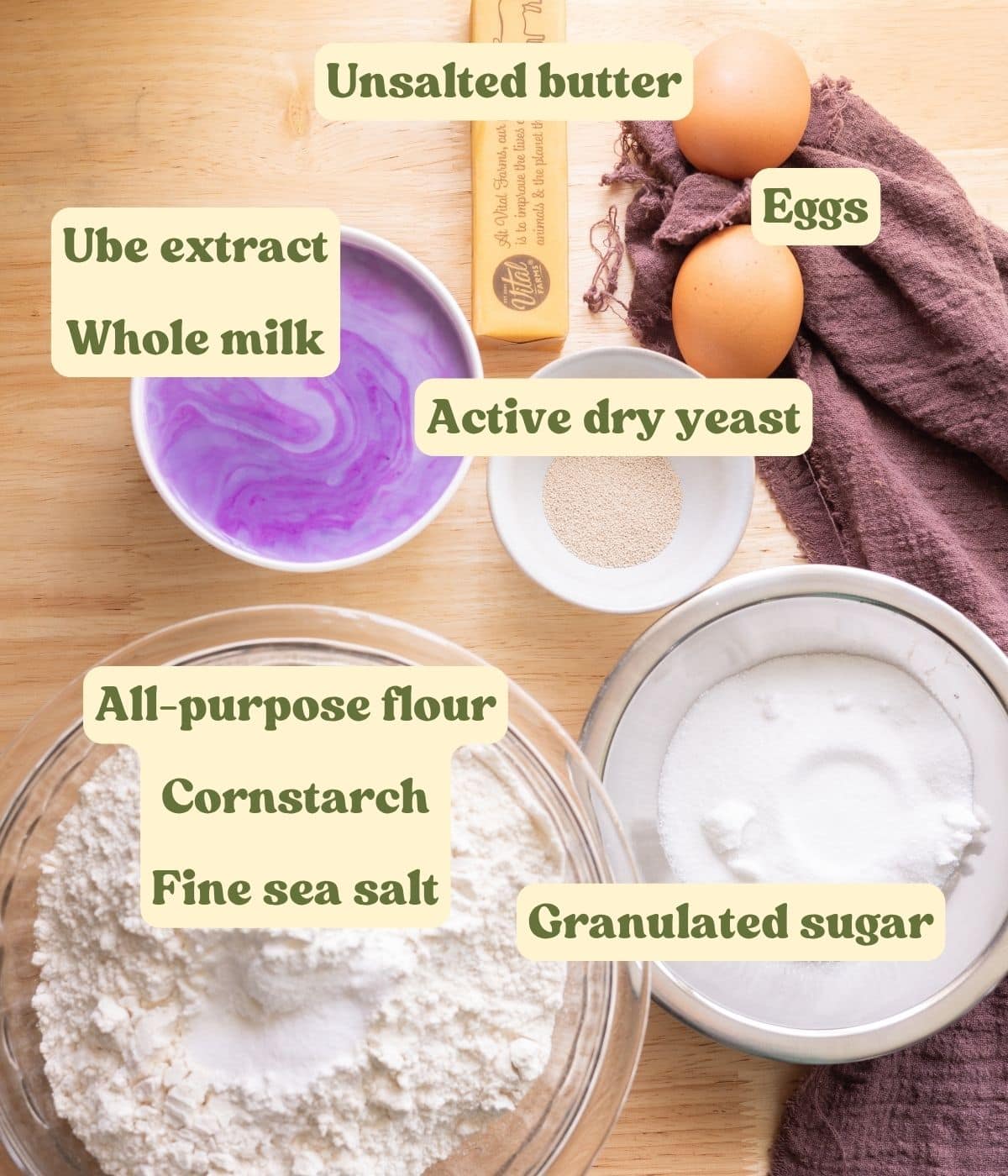 Labeled ube cinnamon roll dough ingredients laid out on a table.