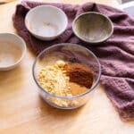 Gingerbread spice mix ingredients in a glass container.