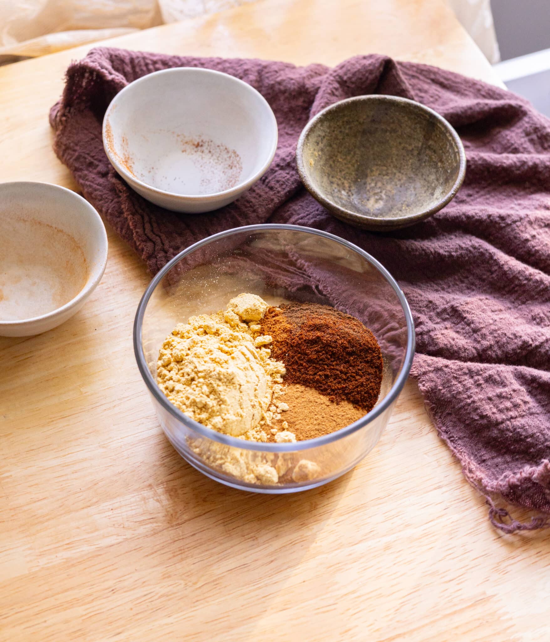 Gingerbread spice mix ingredients in a glass container.