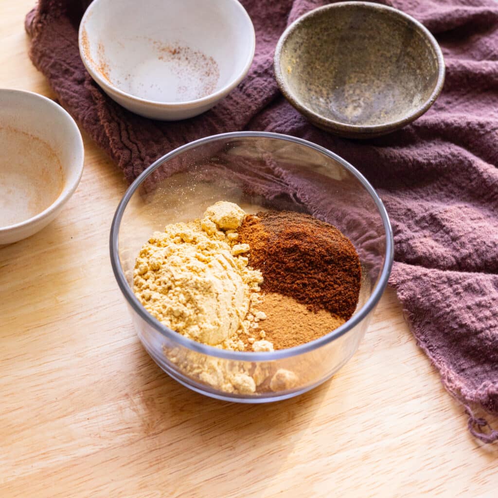 Gingerbread spice mix ingredients in a glass container.