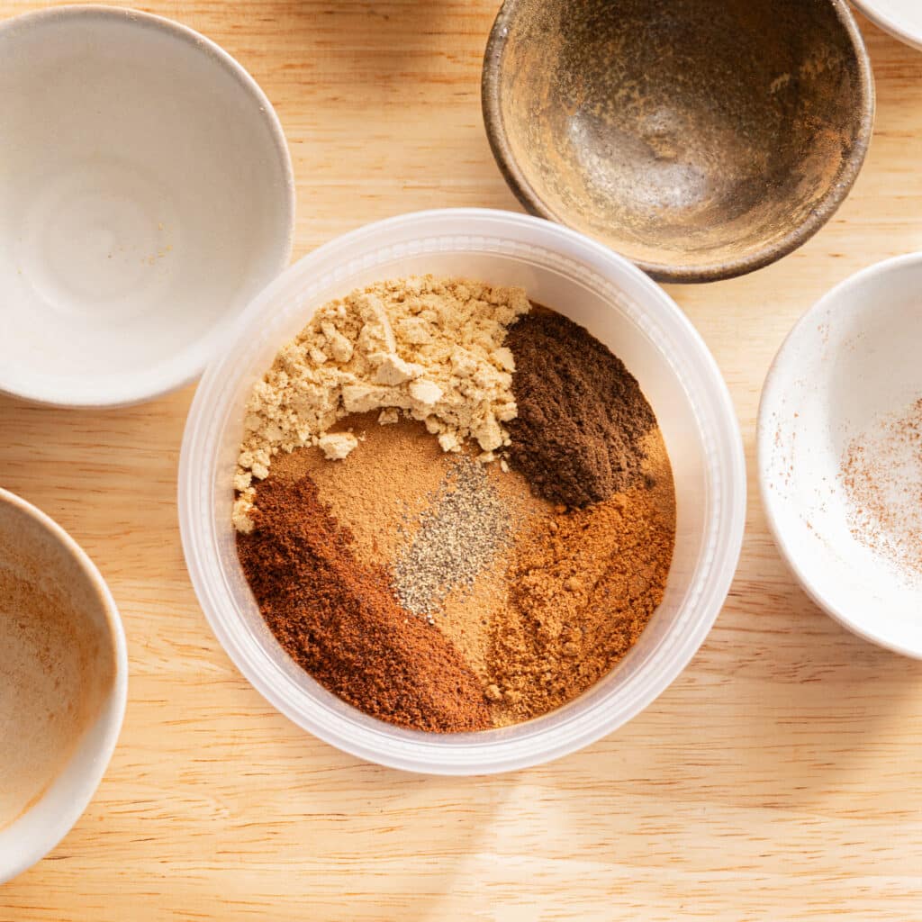 Pumpkin pie spice mix ingredients in a plastic container.