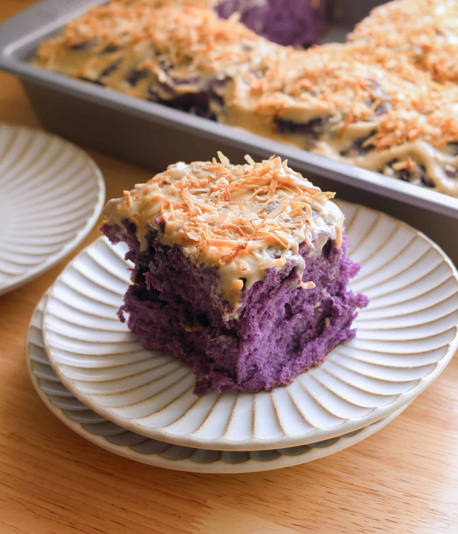 Ube coconut roll on a fluted plate.