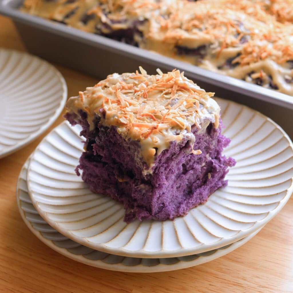 Ube coconut roll on a fluted plate.
