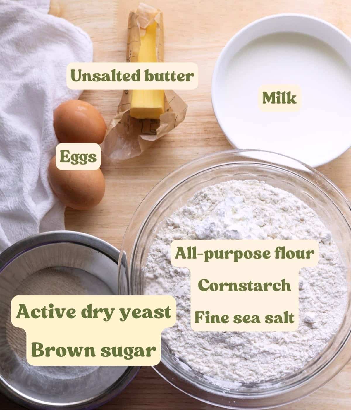 Labeled chai spice cinnamon roll dough ingredients laid out on a table.