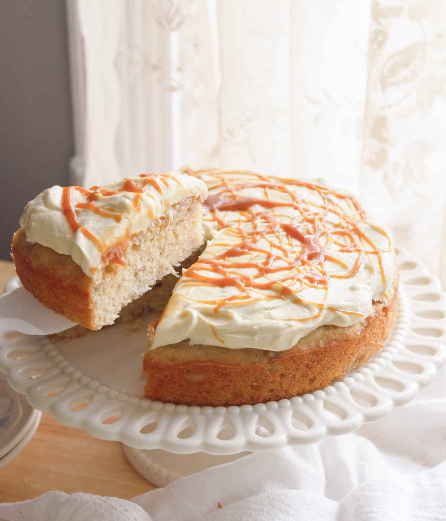 Taking slice of banana cake from cake stand.