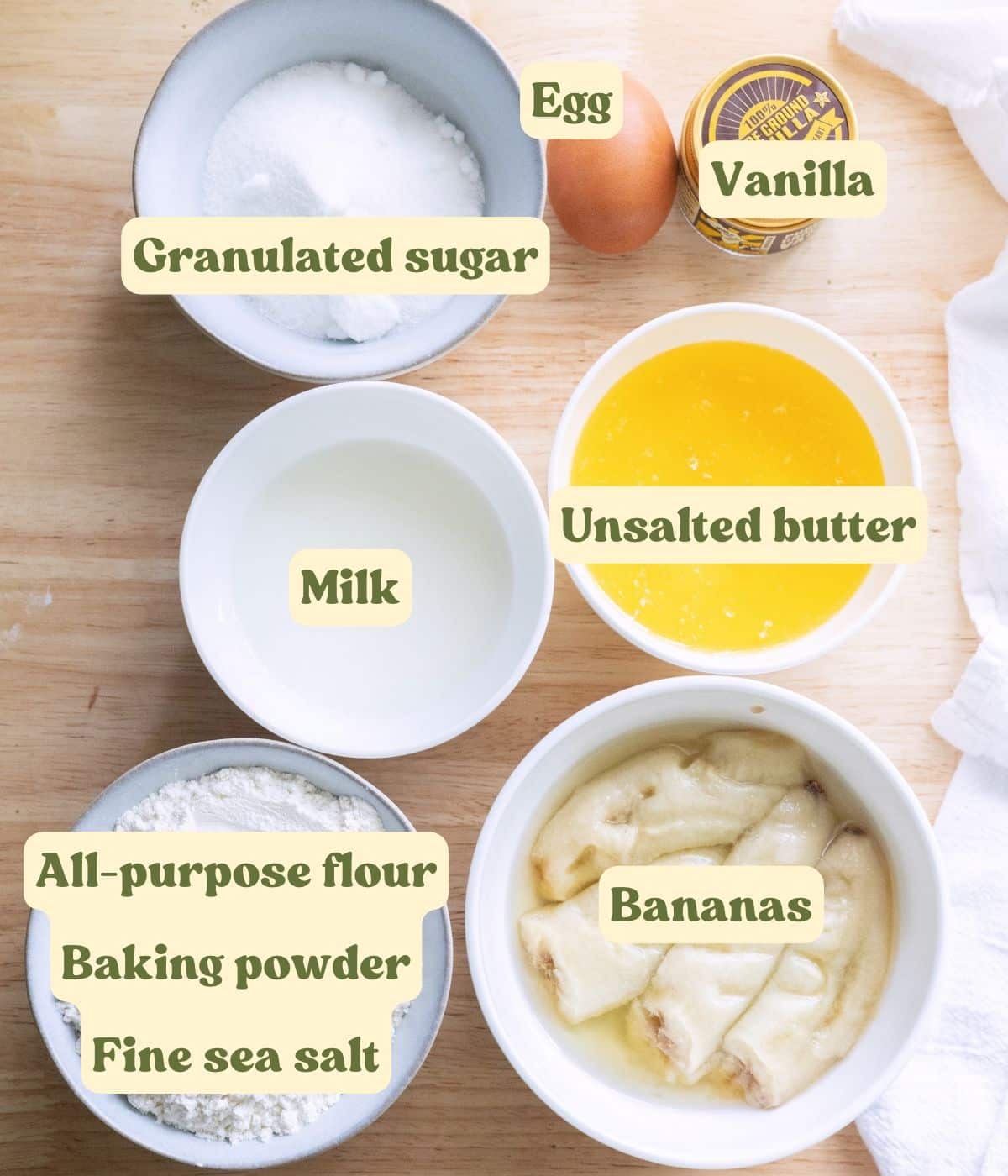 Labeled banana cake ingredients laid out on a table.
